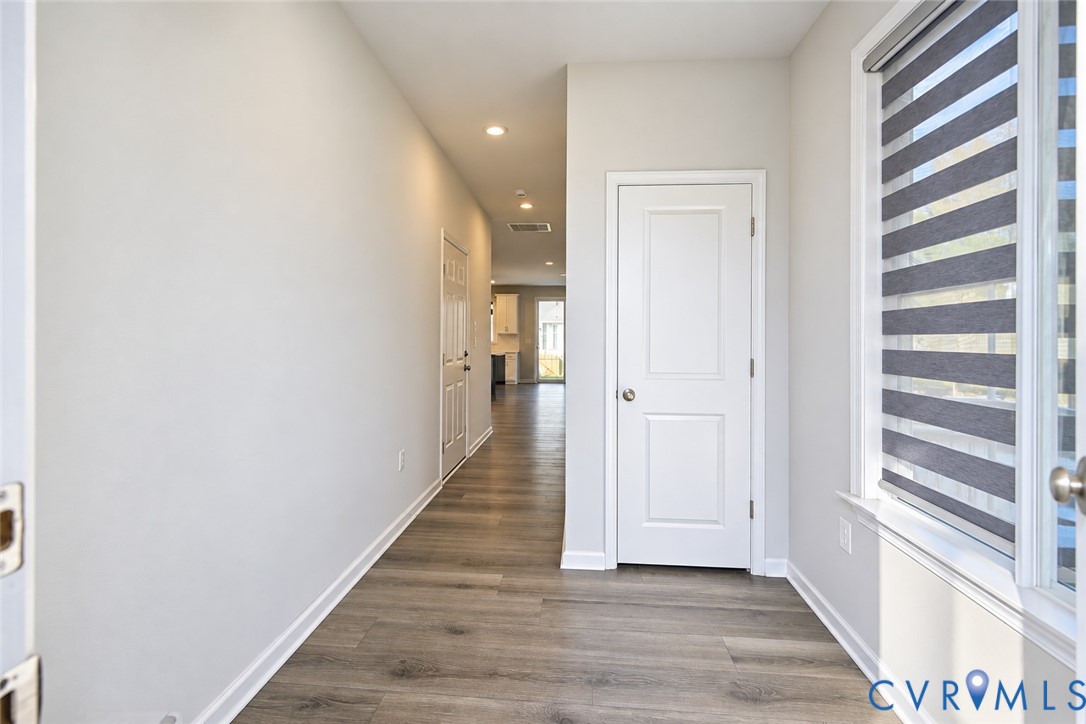 Entryway featuring wood-finish flooring, recessed lighting, and a window with installed dual-tone roller shades Entryway featuring wood-finish flooring, recessed lighting, and a window with installed dual-tone roller shades