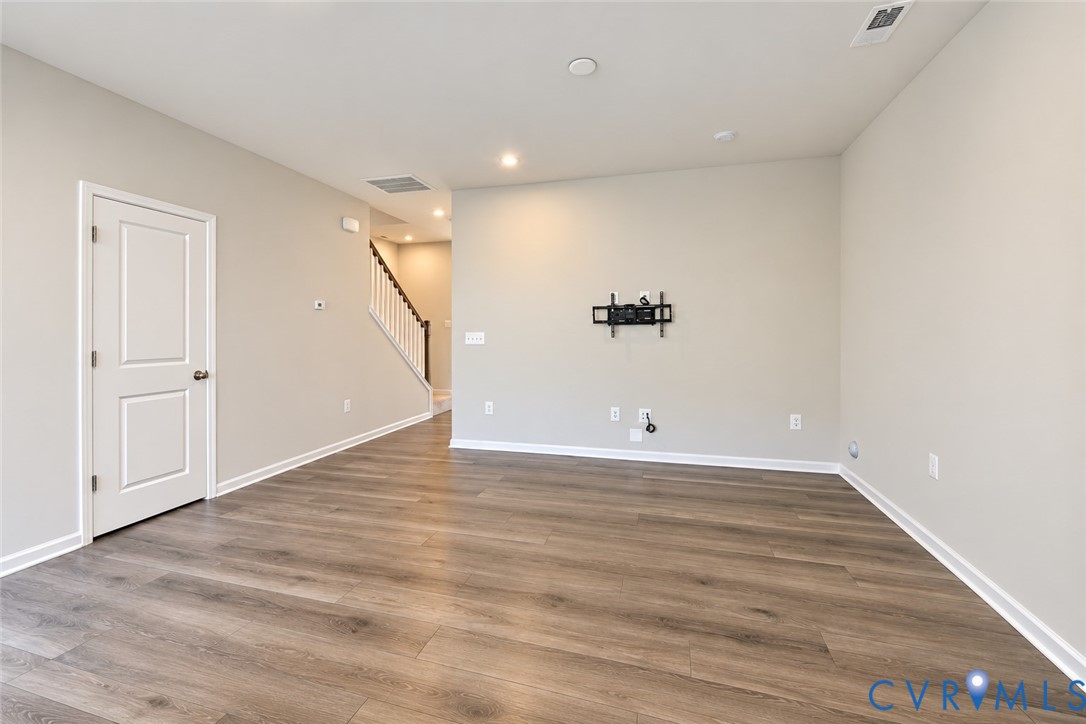 Open-concept interior featuring wood-finish flooring, recessed lighting, and a neutral wall palette