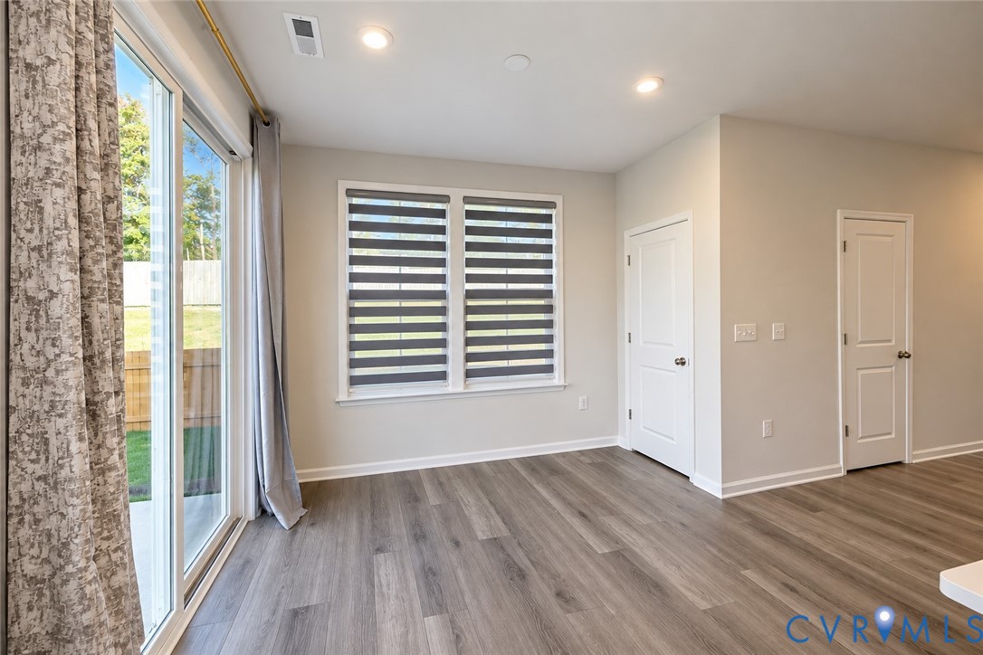 Wood-finish flooring, recessed lighting, dual-panel interior doors, and sliding glass door with dual-window configuration
