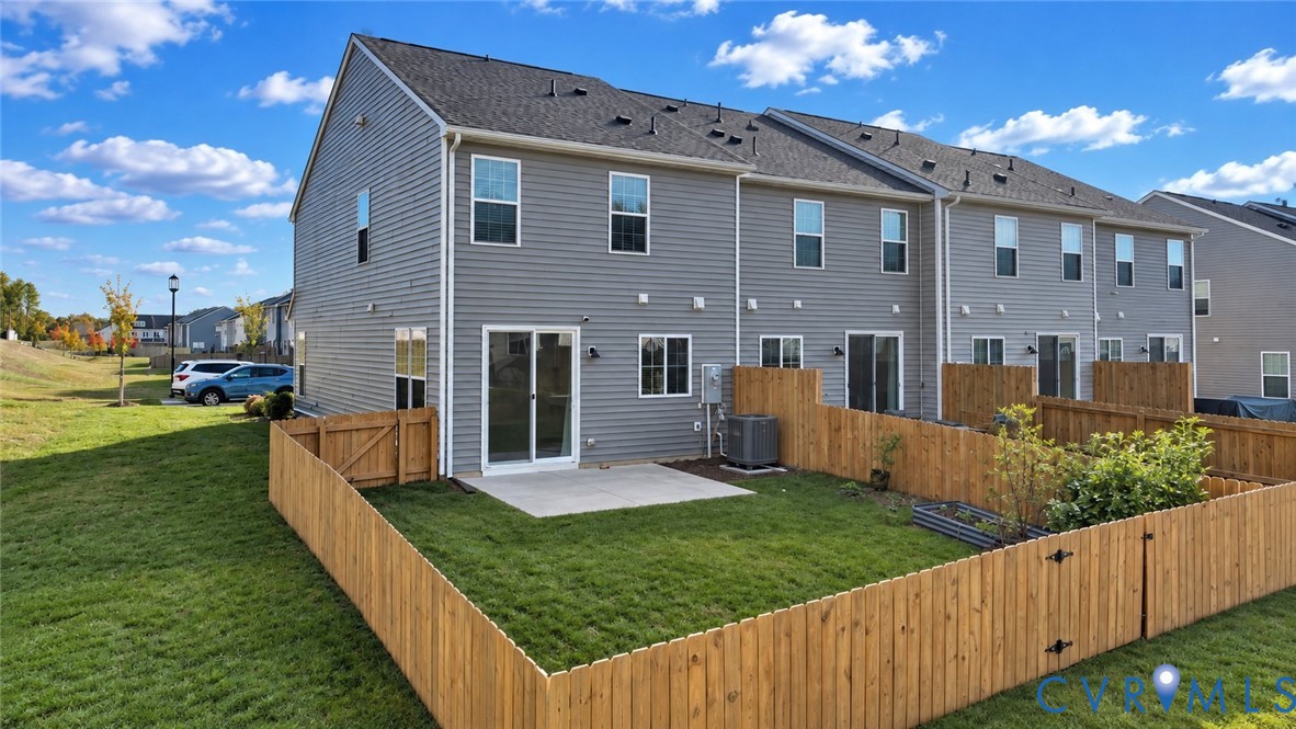 Exterior featuring horizontal vinyl siding, a fenced-in rear lawn, concrete patio, and sliding glass entry door