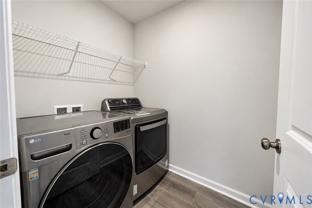 Laundry room featuring wood-finish flooring and a white wire wall-mounted shelving unit
