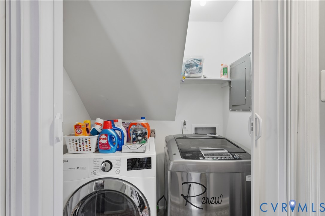 Utility closet featuring white bifold doors, integrated shelving, and dedicated hookups for laundry appliances