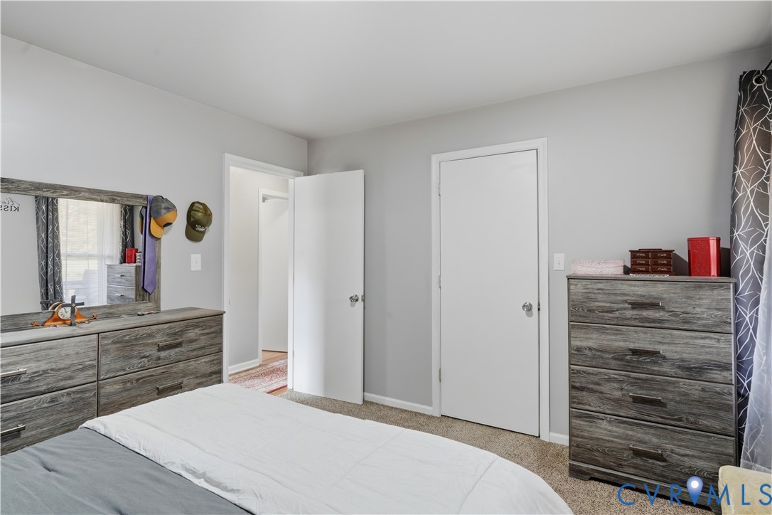 Neutral wall paint, plush carpeting, and two interior doors with hardware