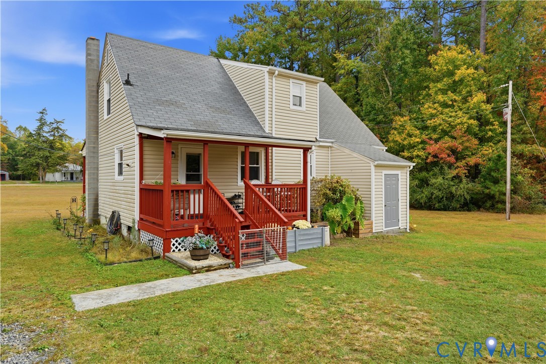 Exterior featuring beige vinyl siding, a covered porch with red painted wood railing, an asphalt shingle roof, and an exterior masonry chimney