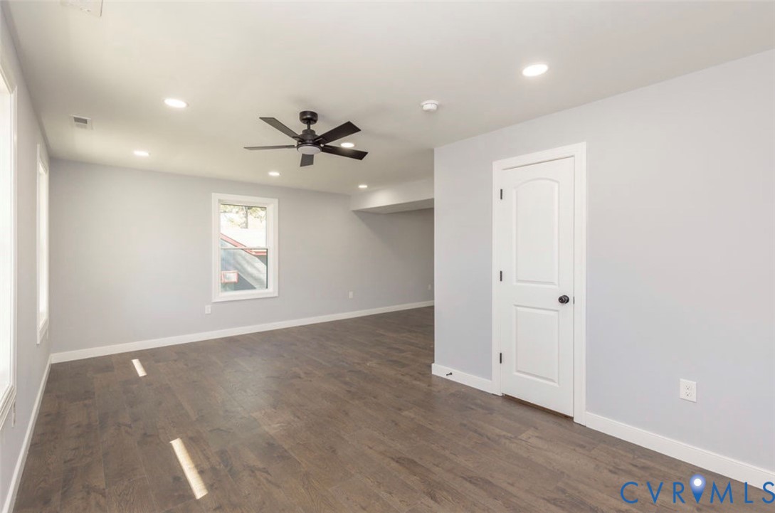 Wood-finish flooring, recessed lighting, matte black ceiling fan, and multi-panel interior door