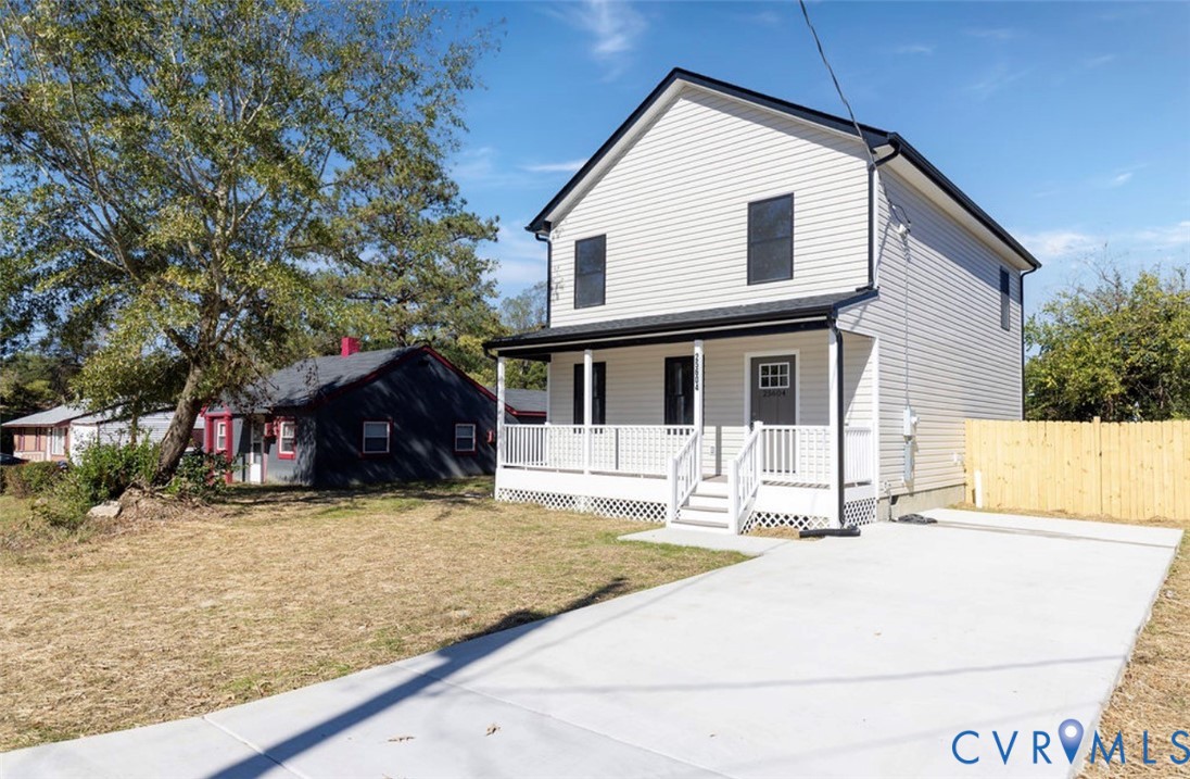 Two-story vinyl siding exterior featuring a covered front porch with lattice skirting and a concrete driveway
