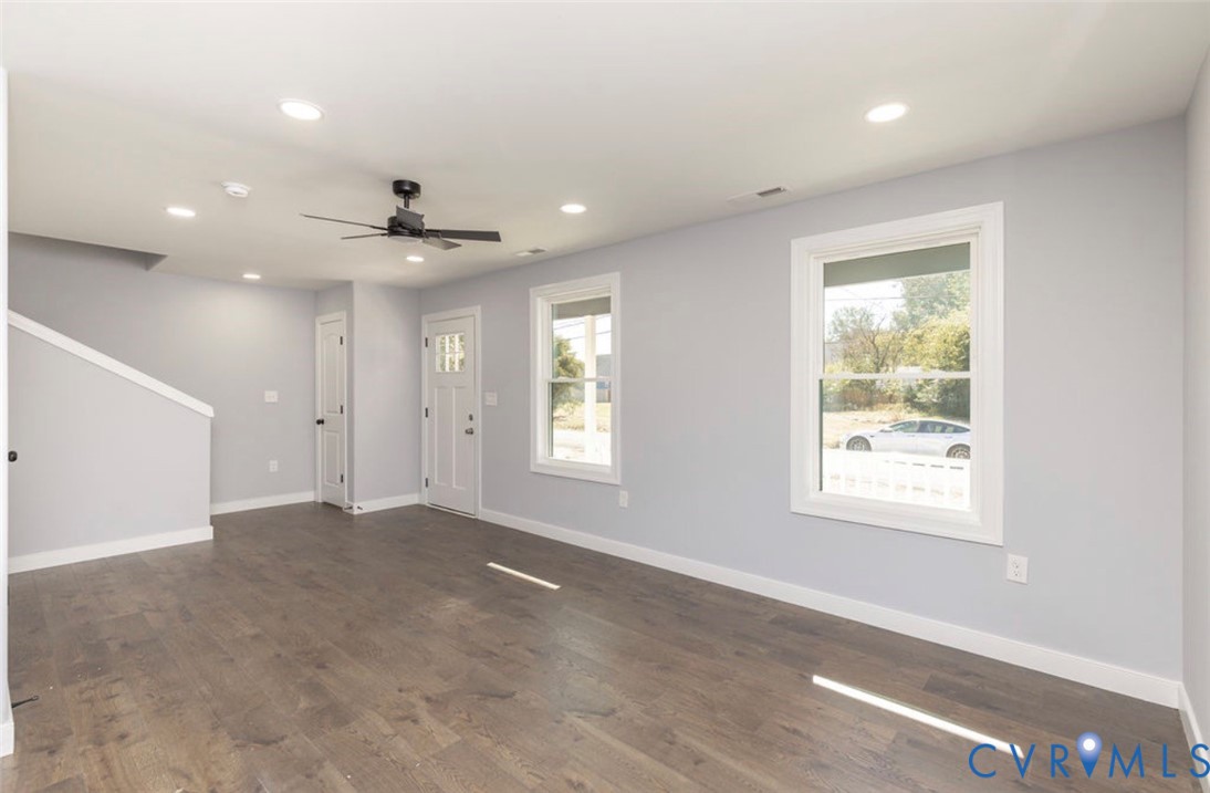 Interior space featuring wood-finish flooring, recessed lighting, a ceiling fan, and white-trim windows