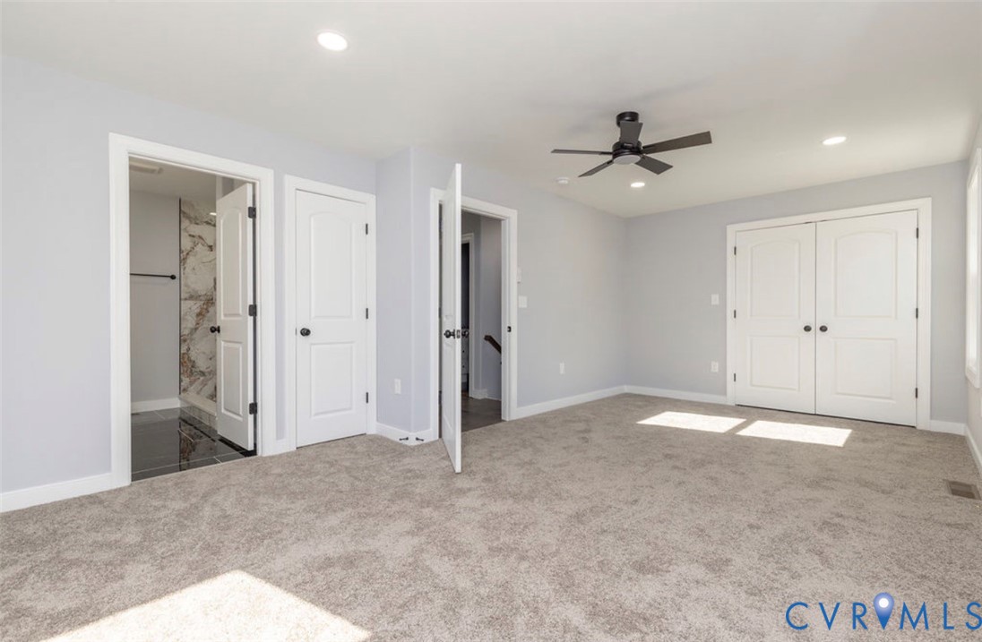 Neutral-toned carpeting, recessed ceiling lighting, matte black finish ceiling fan, double-door closet, and interior passage doors