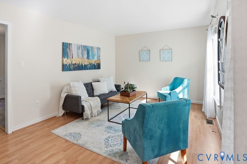 Interior space featuring wood-finish flooring, neutral wall tones, and a large window with natural light