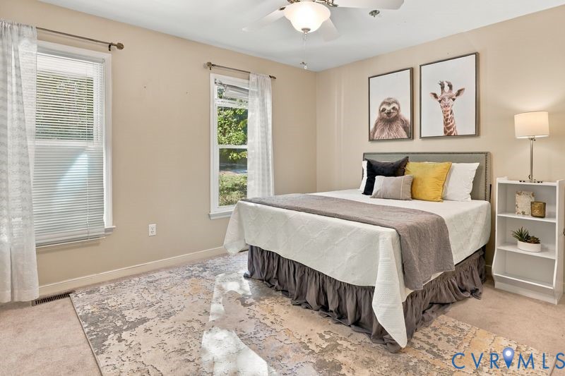 Neutral-toned walls featuring dual windows and a ceiling-mounted light fixture with integrated fan