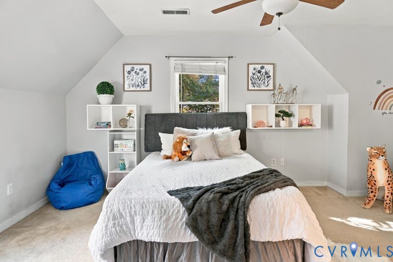 Vaulted ceilings, carpeted flooring, built-in shelving, and a ceiling fan