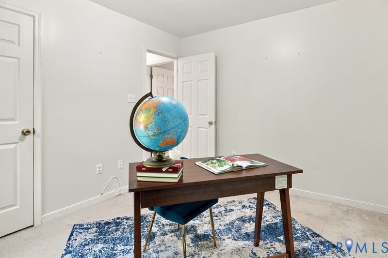 Room featuring white wall finishes, neutral carpeting, and two six-panel interior doors with brass-tone hardware