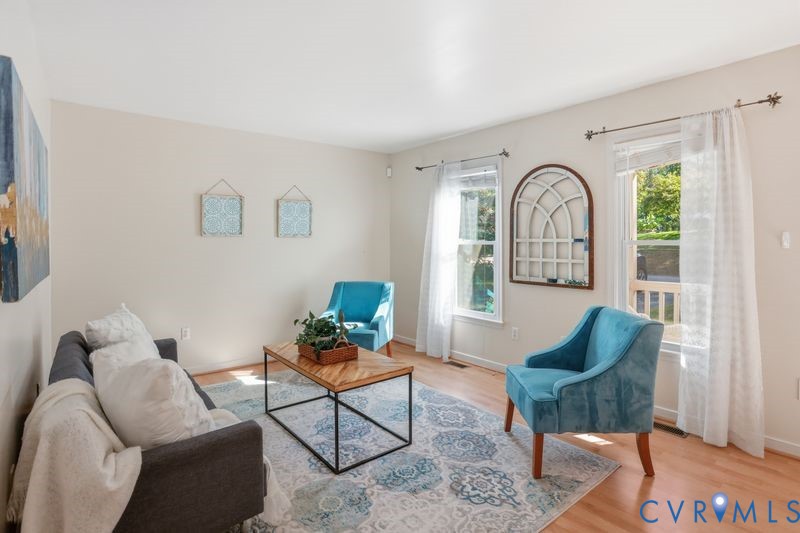 Living area featuring neutral wall paint, wood-finish flooring, and two double-hung windows