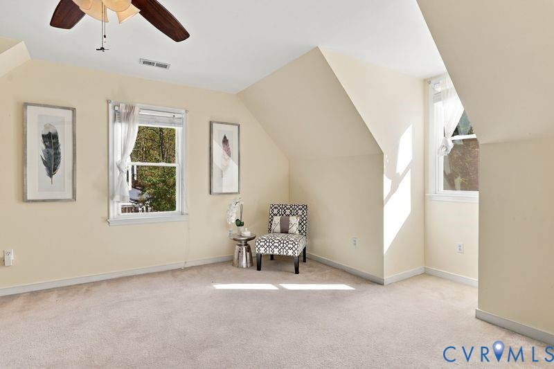 Neutral wall tones, vaulted ceilings, carpeting, and multiple windows