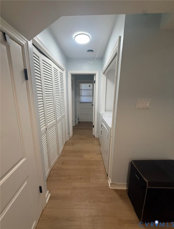 Hallway featuring wood-finish flooring, white louvered closet doors, and flush-mount ceiling lighting