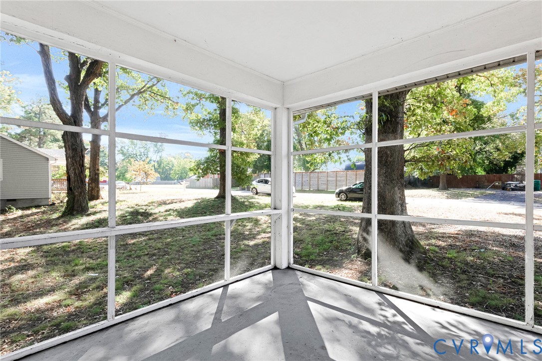 Screened-in porch featuring a painted concrete floor and extensive white-framed window panels