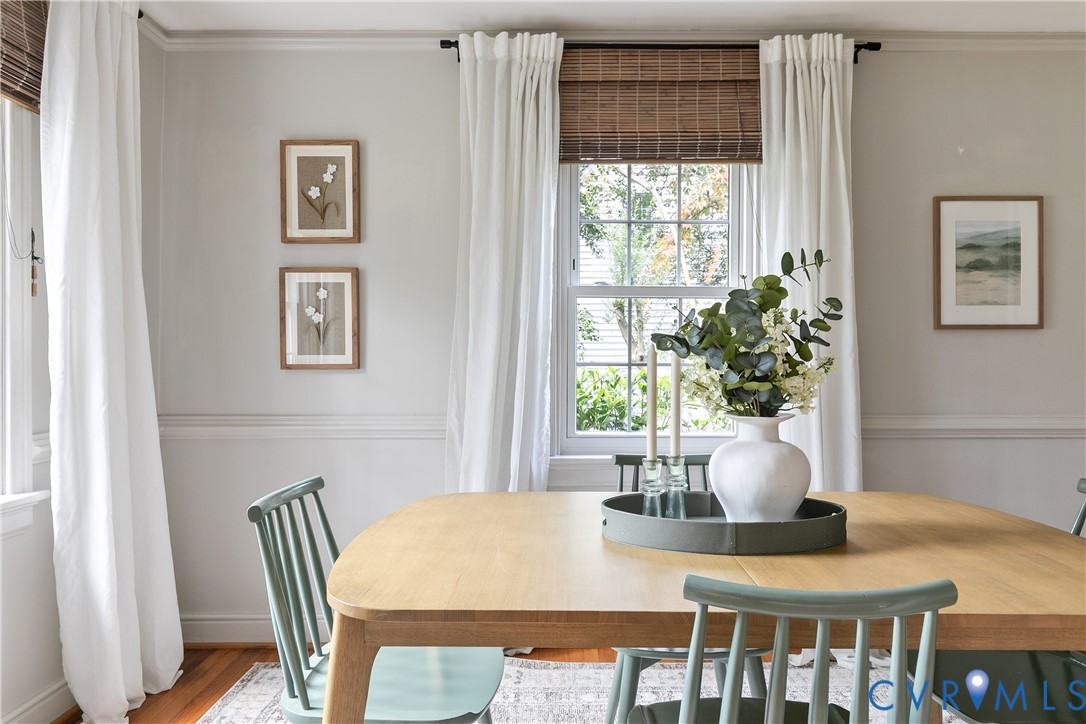 Hardwood flooring, crisp wainscoting, and multi-pane windows with woven wood shades