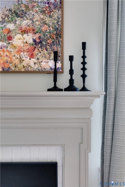 Fireplace mantel featuring stepped decorative crown molding and an integrated brick surround