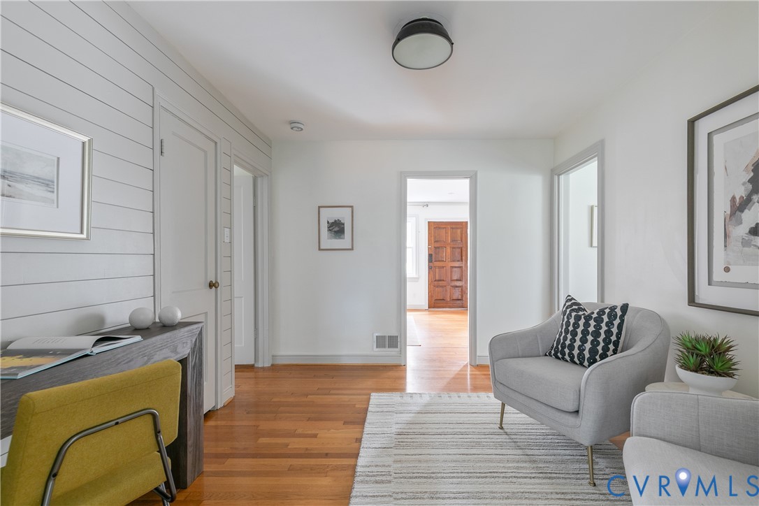 Interior space featuring horizontal shiplap wall paneling, wood-finish flooring, and a dome-style flush-mount ceiling light fixture