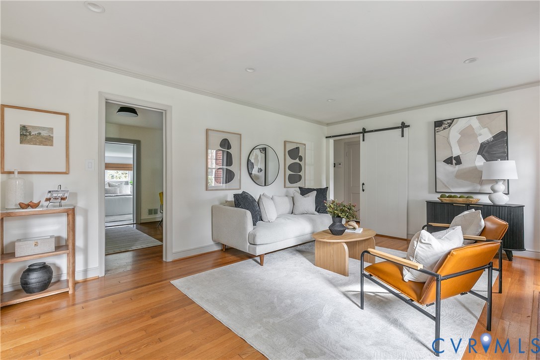 Interior space featuring wood-finish flooring, recessed lighting, and a white sliding barn door with black iron hardware