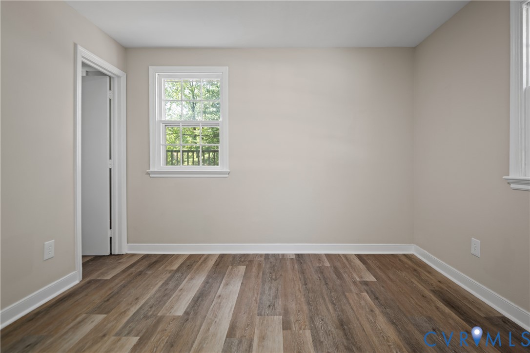 Neutral-toned interior space featuring wood-finish flooring and double-hung windows