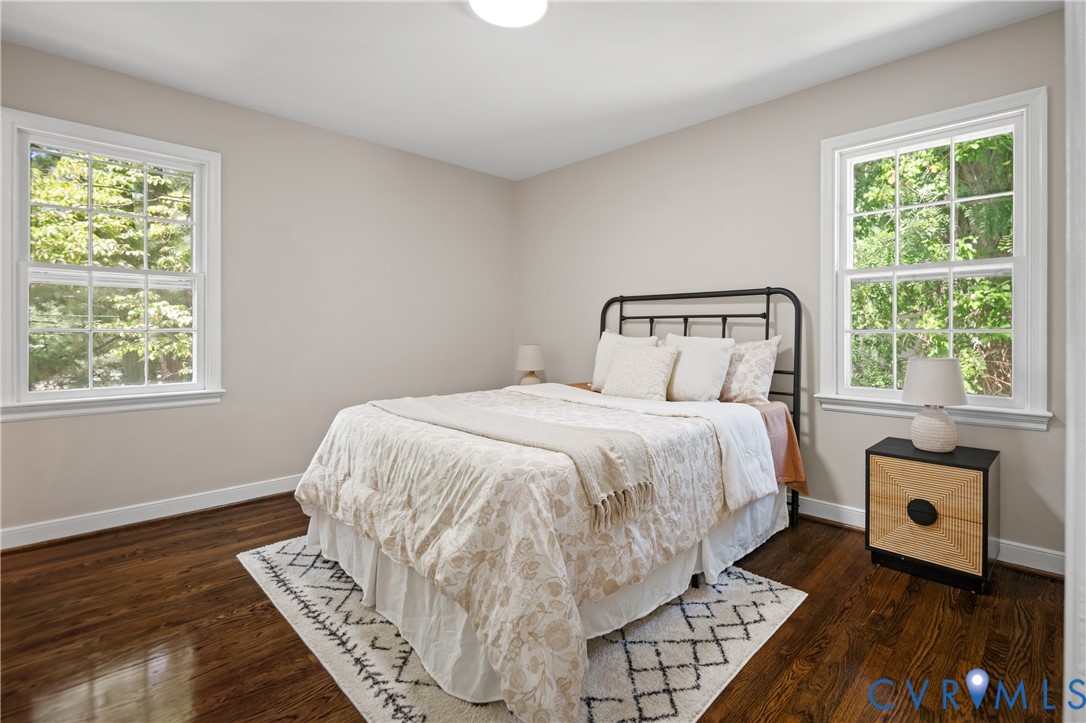 Hardwood flooring, neutral wall tones, and dual grid-pane windows providing natural light