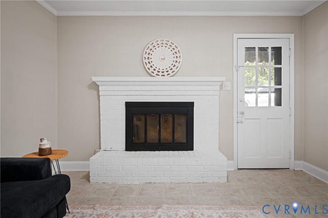 White brick fireplace featuring a black metal insert and a wide mantel, alongside a multi-pane glass entry door