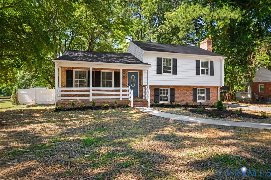 2026 Roof, Split-level exterior featuring brick and horizontal siding, a covered front porch with white railing, and dark shutters