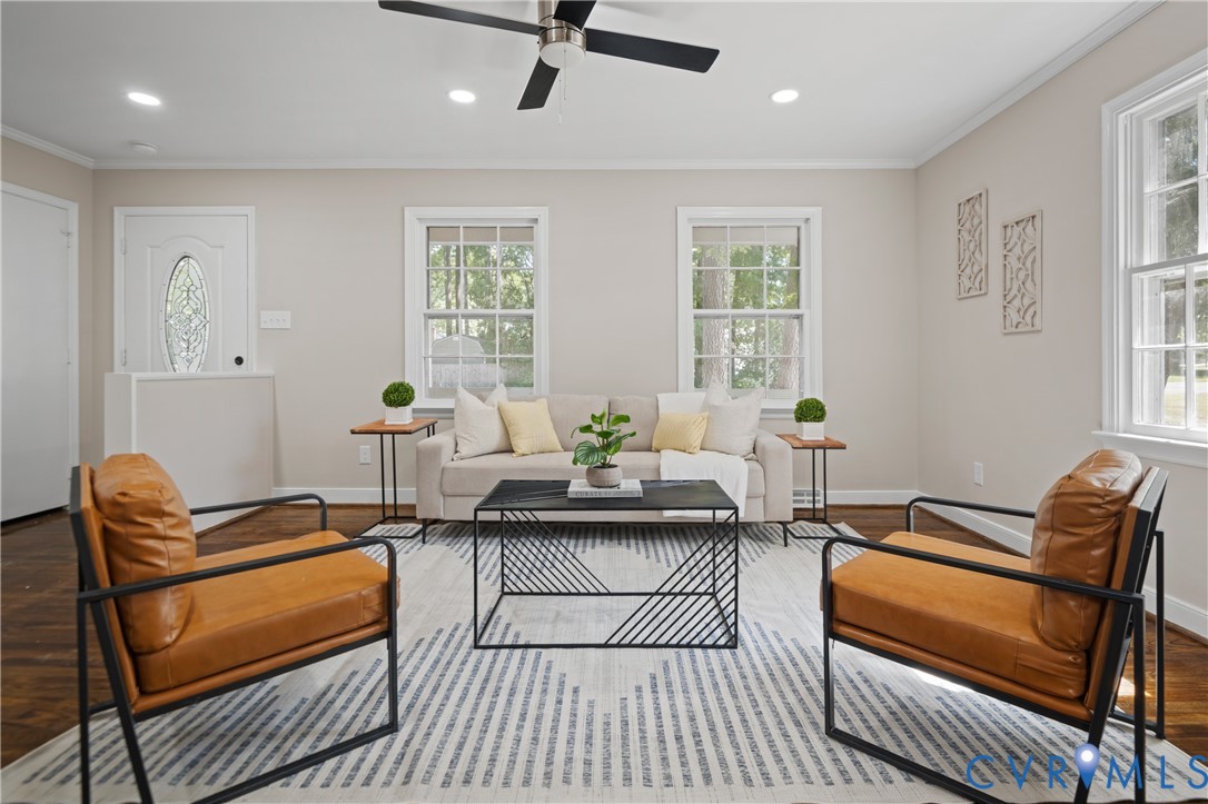 Living area featuring wood-finish flooring, recessed lighting, a ceiling fan, and double-hung windows