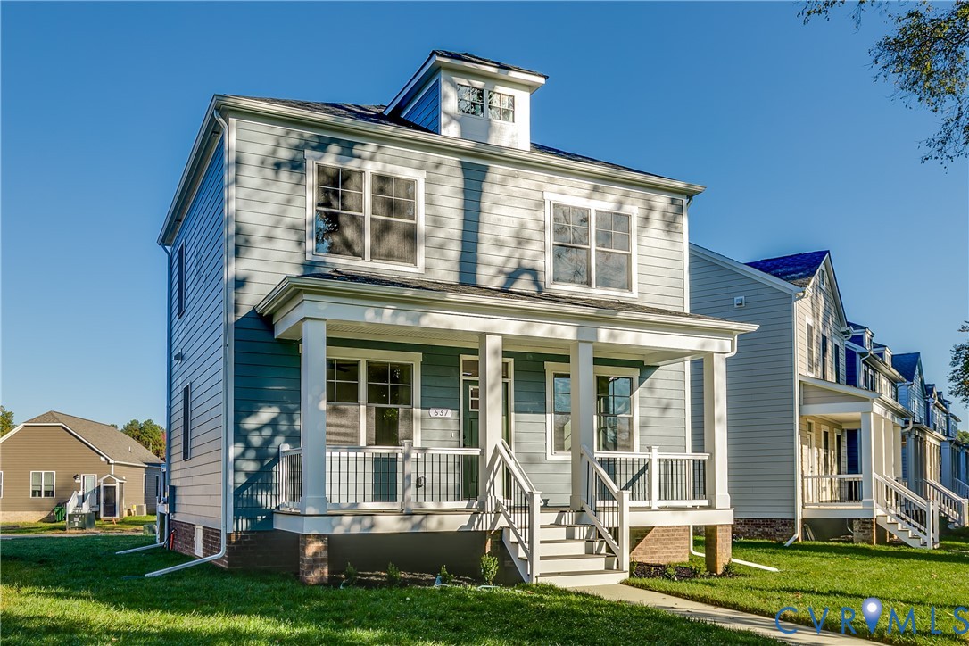 Two-story exterior with horizontal siding, a covered front porch featuring square columns and metal railing, and a gabled dormer roofline