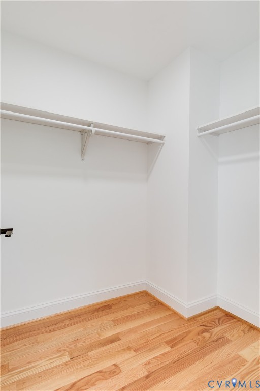 Storage space featuring wood-finish flooring and dual tiers of white shelving