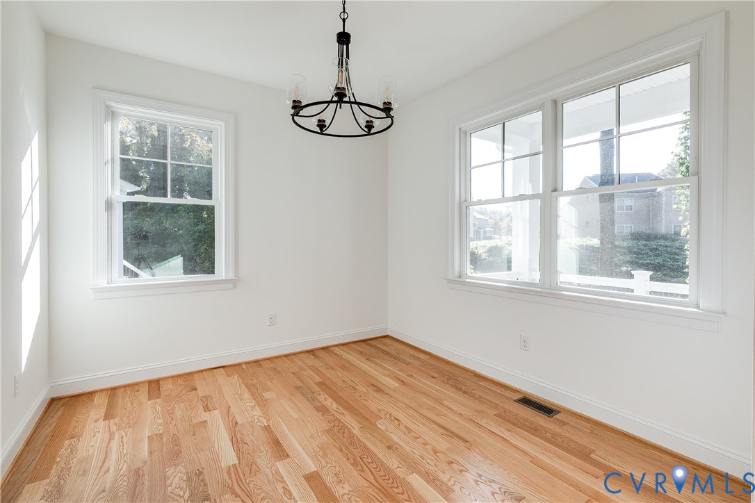 Wood-finish flooring, multi-pane windows, and a black-finish metal chandelier