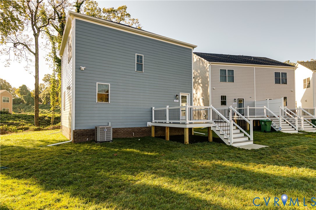 Exterior featuring horizontal lap siding, a brick foundation, and a raised composite deck with white railings and staircase