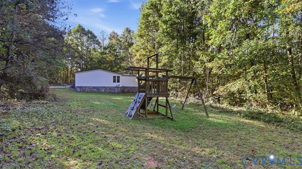 Expansive grounds featuring a natural wooded border and stone-veneer foundation detail