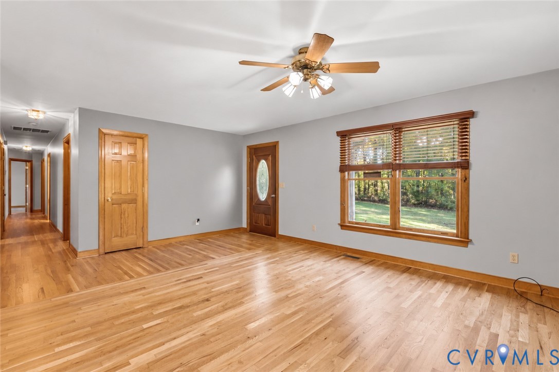 Interior space featuring wood-finish flooring, solid wood doors, and a ceiling fan with integrated light fixture
