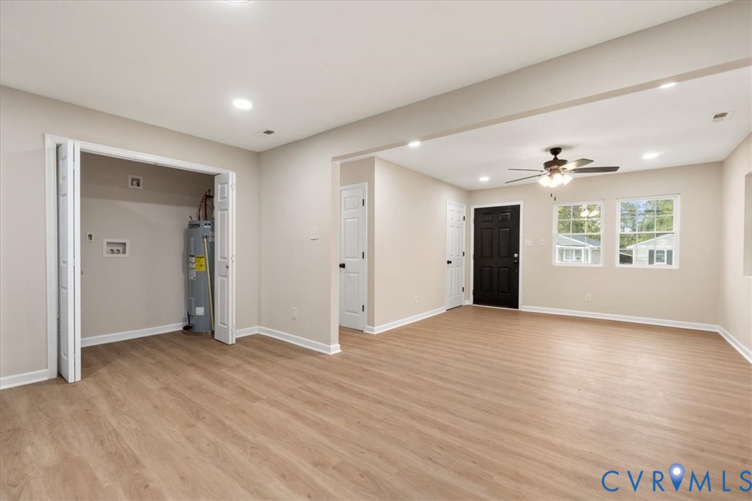 Open-concept room featuring wood-finish flooring, recessed lighting, a ceiling fan with integrated lighting, and a utility closet with bifold doors Open-concept room featuring wood-finish flooring, recessed lighting, a ceiling fan with integrated lighting, and a utility closet with bifold doors