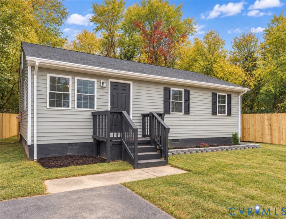 Exterior featuring light gray horizontal siding, dark gray shutters, an elevated wooden porch entry, and a concrete block foundation base