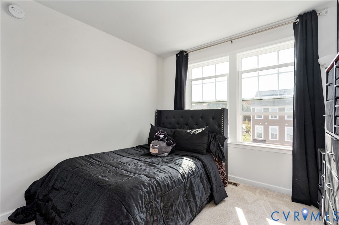 Another view of the third bedroom highlights its paired windows and versatile layout.