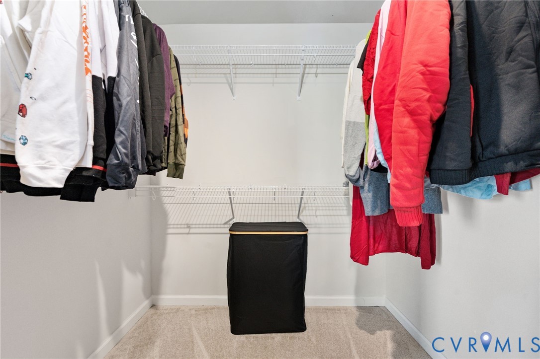 A walk-in closet offers hanging space and shelving on multiple sides to keep clothing and everyday essentials organized.