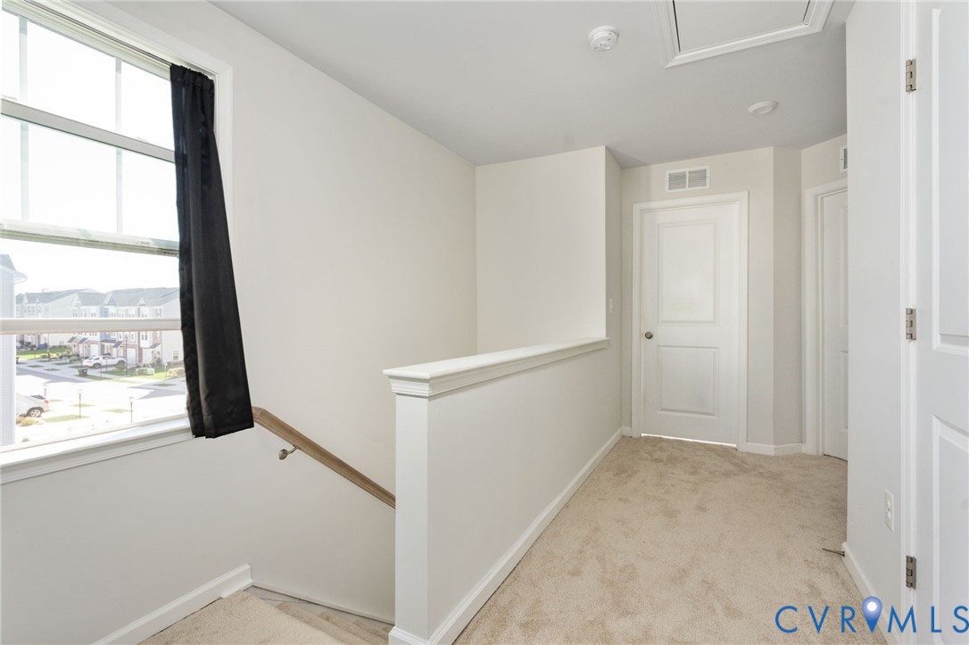 A large window brightens the third-level landing, connecting the bedrooms, hall bath, and laundry area.