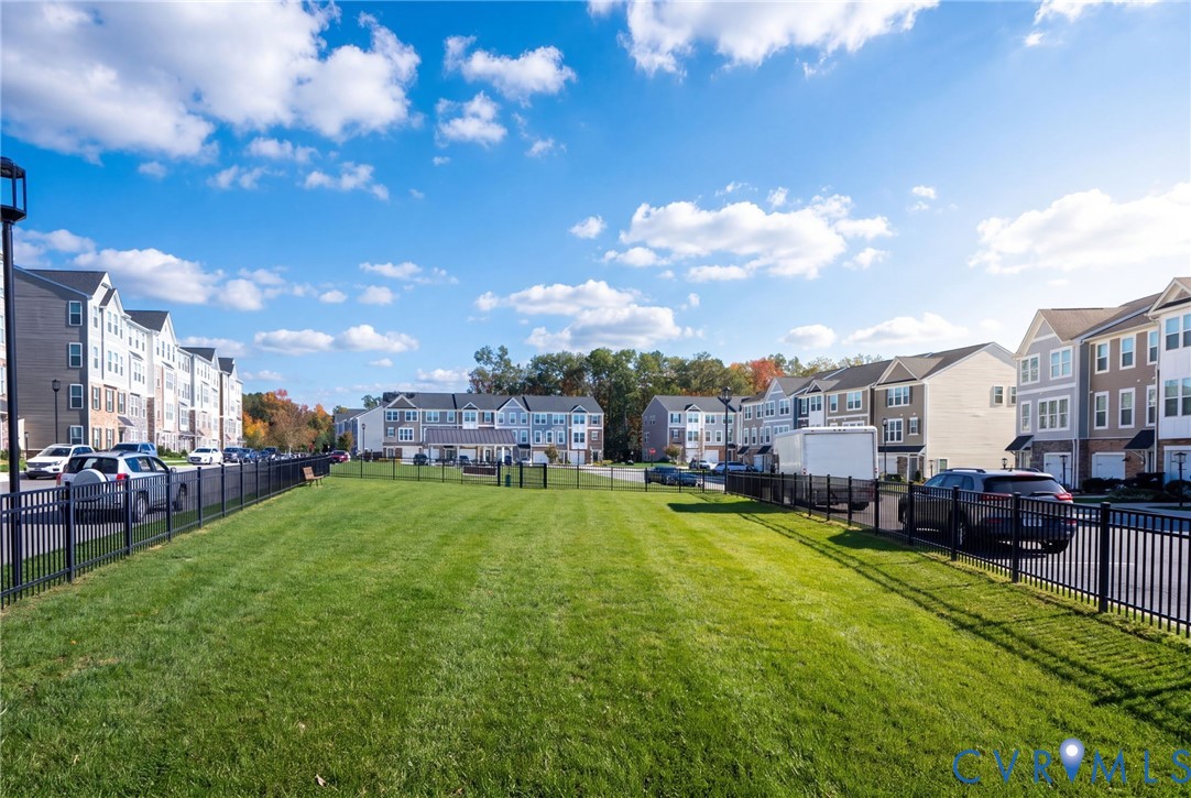 A fenced dog park with bench seating adds open green space to the neighborhood.