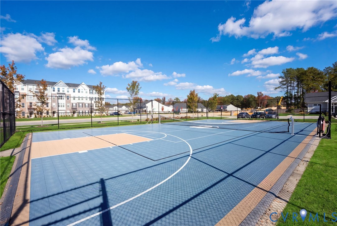 Enjoy outdoor recreation on the fenced community sports court, featuring basketball markings and a net for court games.