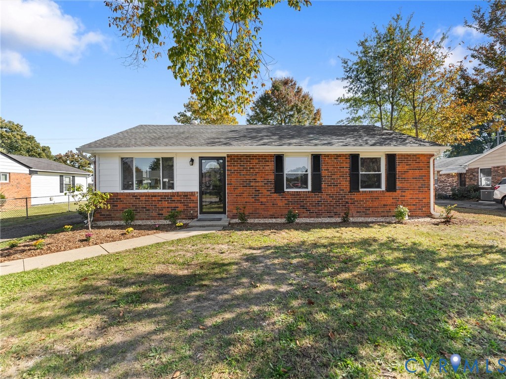 Single-story brick and siding exterior featuring dark shutters, a front walkway, and mature trees Single-story brick and siding exterior featuring dark shutters, a front walkway, and mature trees