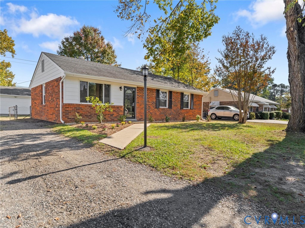 Single-story brick and siding exterior featuring a gable roof, decorative window shutters, and a concrete walkway