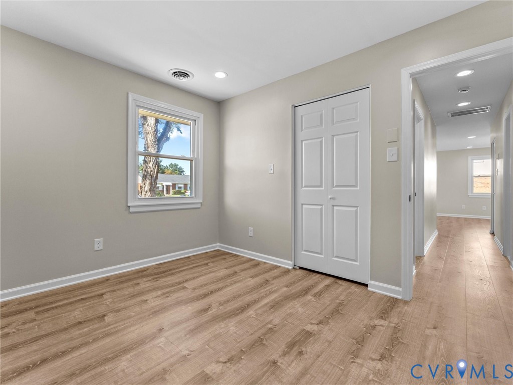 Interior space featuring light-toned wood-finish flooring, recessed lighting, neutral wall paint, and a double-panel closet door