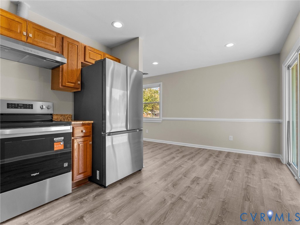 Kitchen featuring wood cabinetry, stainless steel appliances, recessed lighting, wood-finish flooring, and sliding glass doors