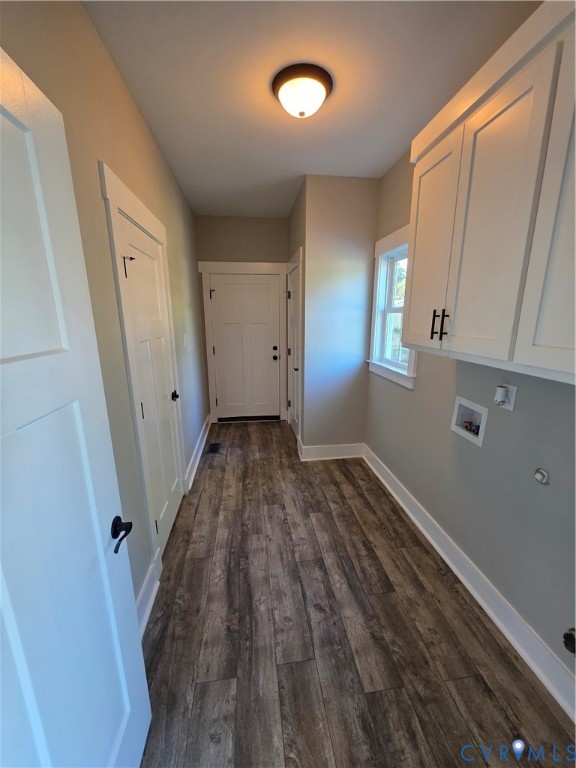 Utility area featuring wood-finish flooring, white shaker-style cabinetry with matte black hardware, and an overhead flush-mount light fixture