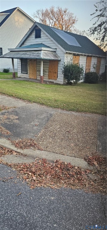 sSingle-story cottage with horizontal siding, a gabled roofline, and a covered front porch on a corner lot with handicapped curb cut at sidewalk sSingle-story cottage with horizontal siding, a gabled roofline, and a covered front porch on a corner lot with handicapped curb cut at sidewalk