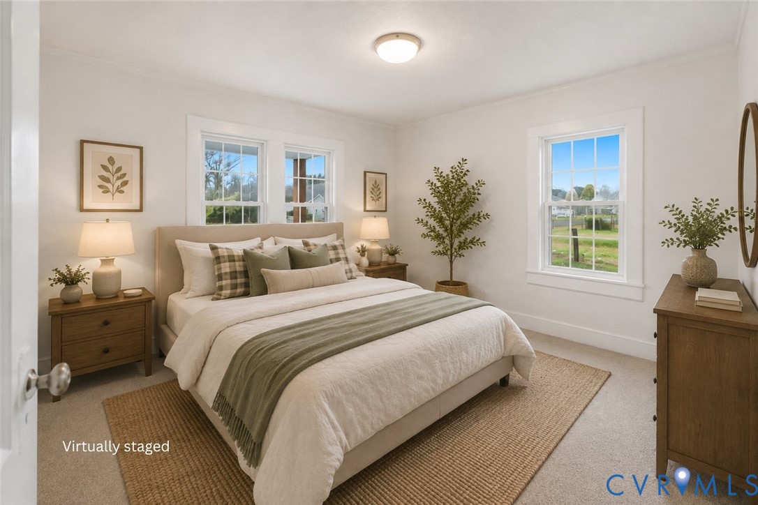 Bedroom featuring neutral wall-to-wall carpeting, three double-hung windows with white millwork trim, and a ceiling-mounted light fixture