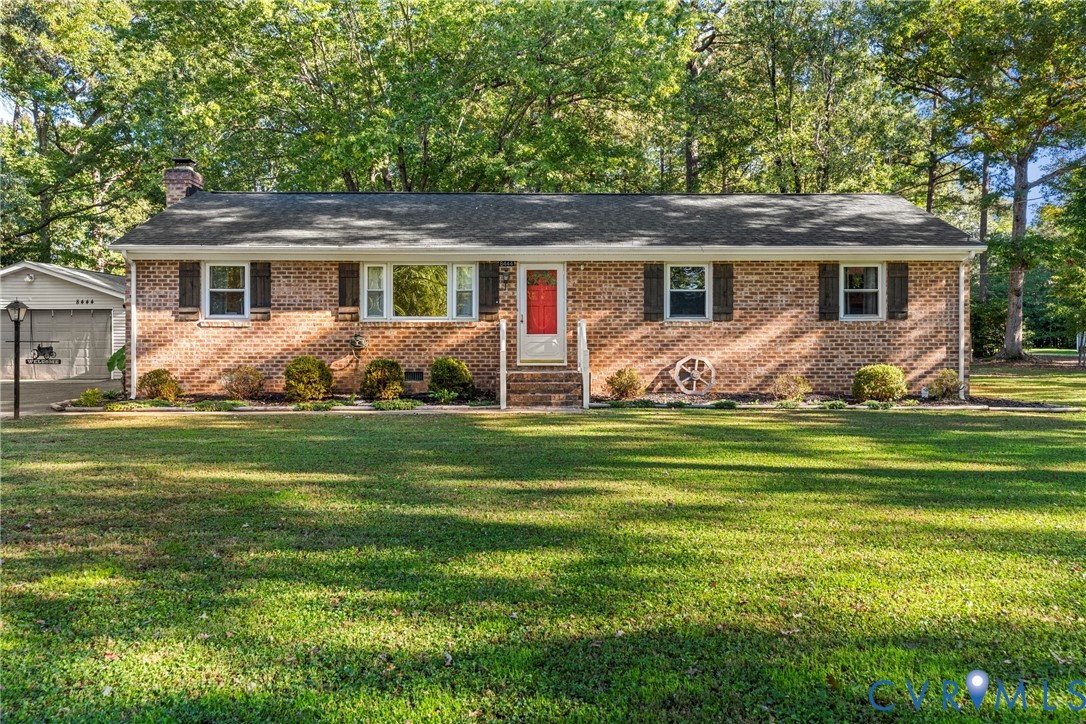 Single-story brick exterior featuring a multi-pane window configuration, asphalt shingle roof, attached garage, and expansive lawn Single-story brick exterior featuring a multi-pane window configuration, asphalt shingle roof, attached garage, and expansive lawn